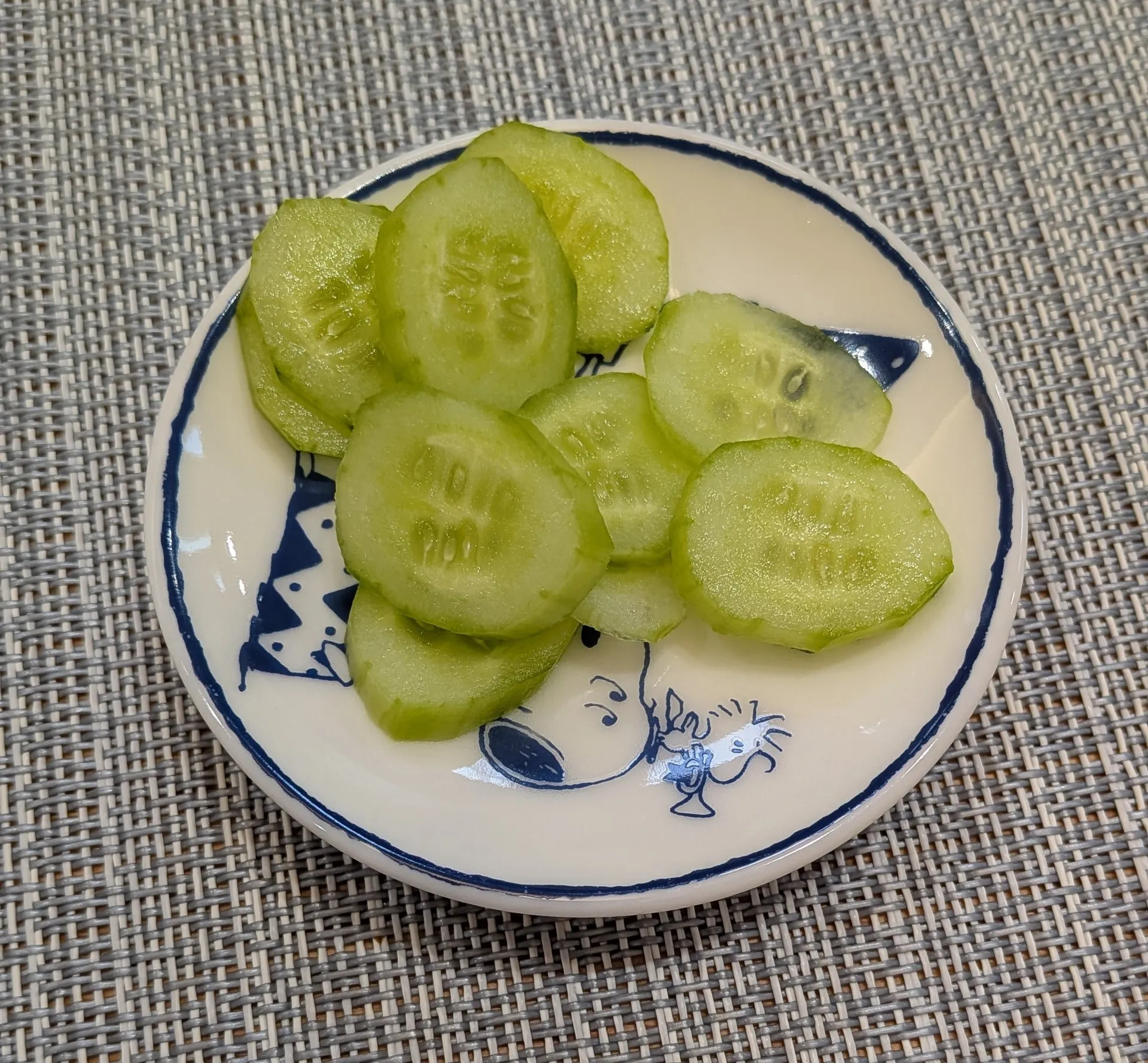 小皿に盛った皮むき薄切りの冷やしきゅうり