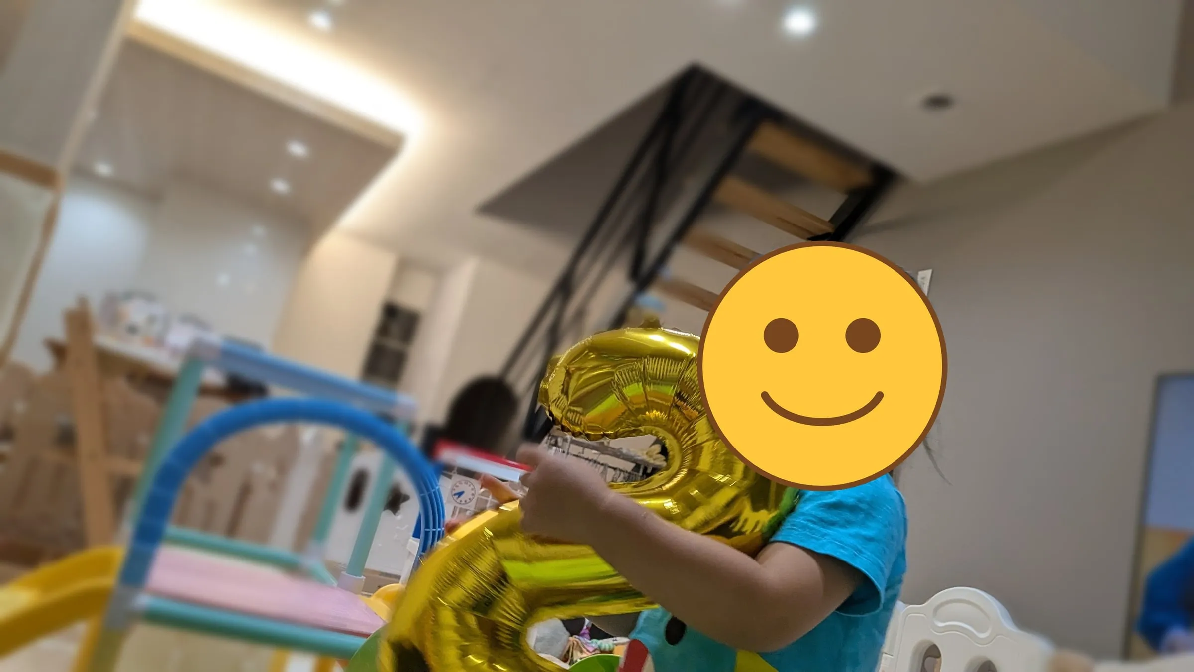 金色の2の風船を抱きかかえるこども