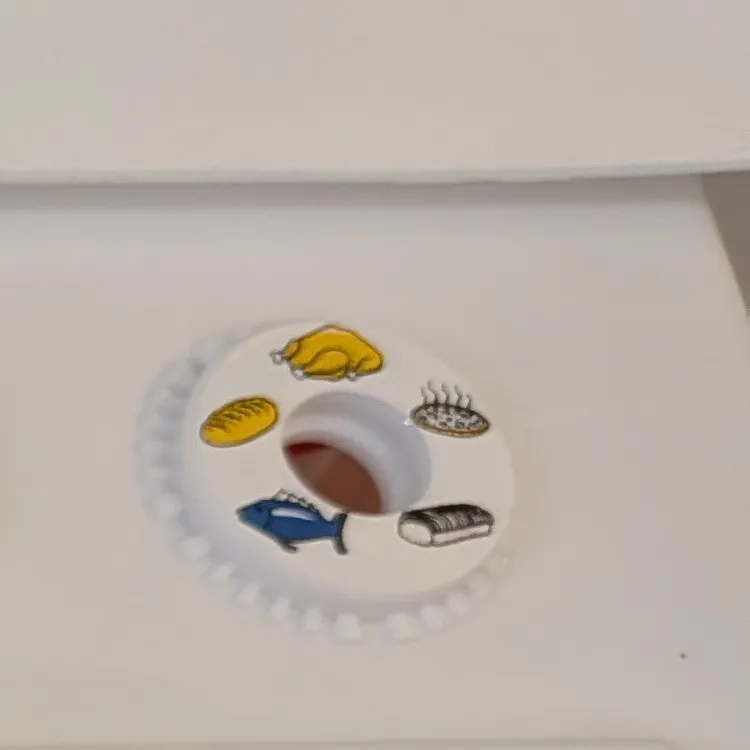 オーブンダイヤルの絵柄のアップ。丸鶏・パン・おさかな・湯気の立つ丸い料理と、縞模様のかたまり